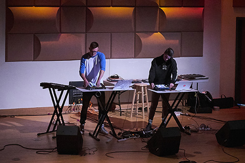 Duo performs live on stage with drum machiens